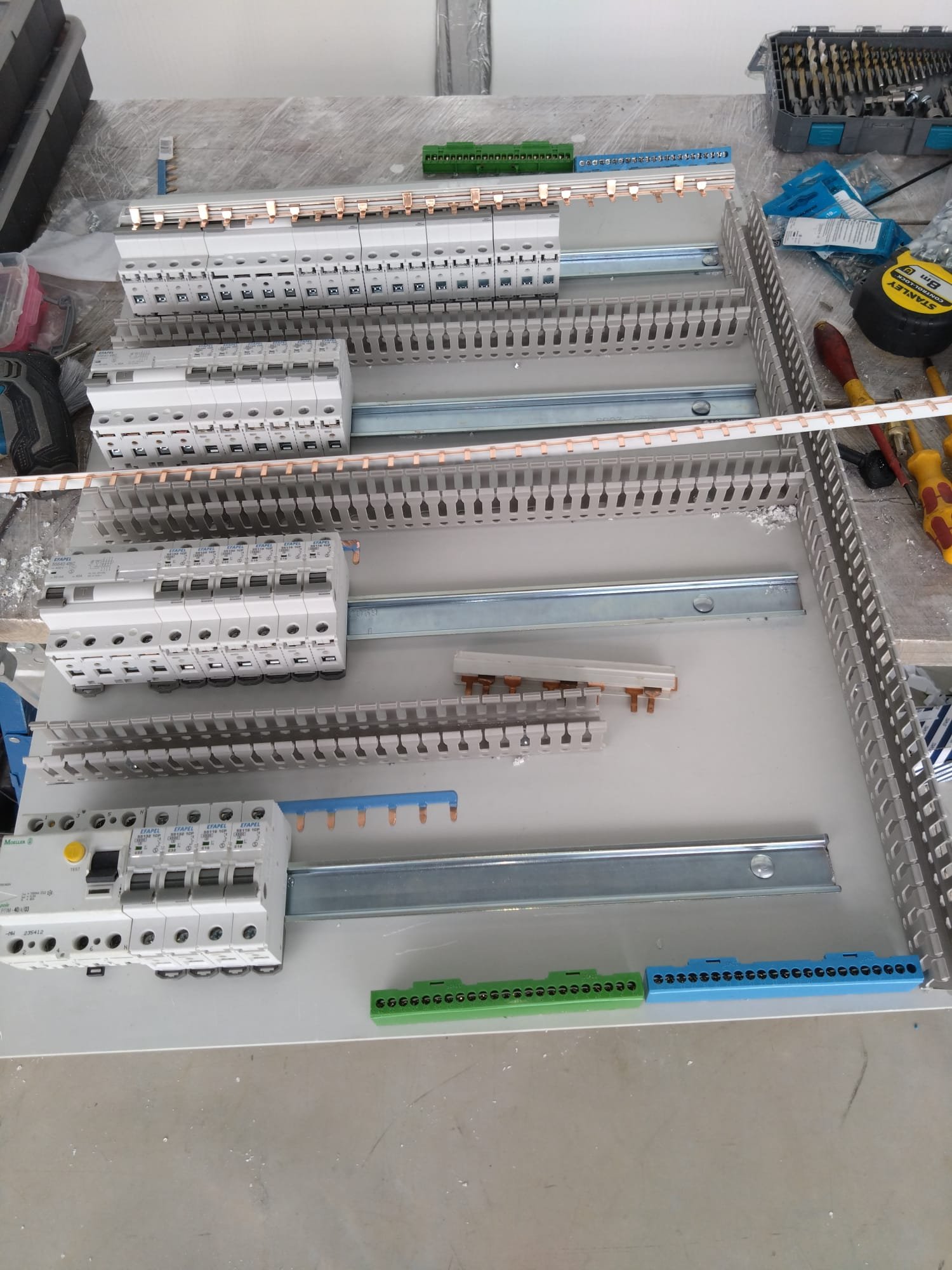New distribution board being assembled on the bench, with breakers, RCDs and terminal bars on DIN rails